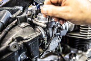 This pic shows Murray loosening the band clamps on a triumph america 790 to take off the stock carburetors. 