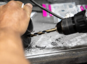 Drilling out and cleaning holes for our brass fittings to snugly fit inside Murray's Carbs pod filters. 