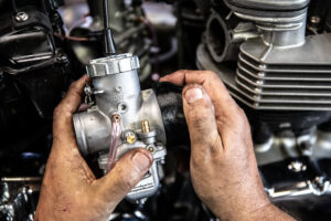 Pressing Murray's greased air box boots onto the MIkuni carbs gently. 