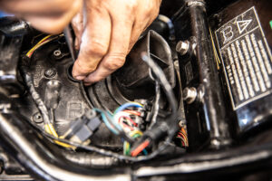 Removing the last remaining screws to remove the stock air box lid on a triumph america speedmaster. 