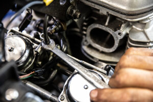 Removing the throttle cables from the throttle body fixture on a Triumph Speedmaster America. 