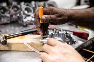 Using a pick to punch out a Mikuni VM series float pin for repair. 