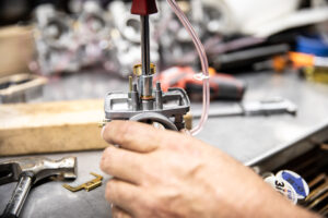 Using a 10mm socket to remove the needle seat from a Mikuni VM series carburetor. 